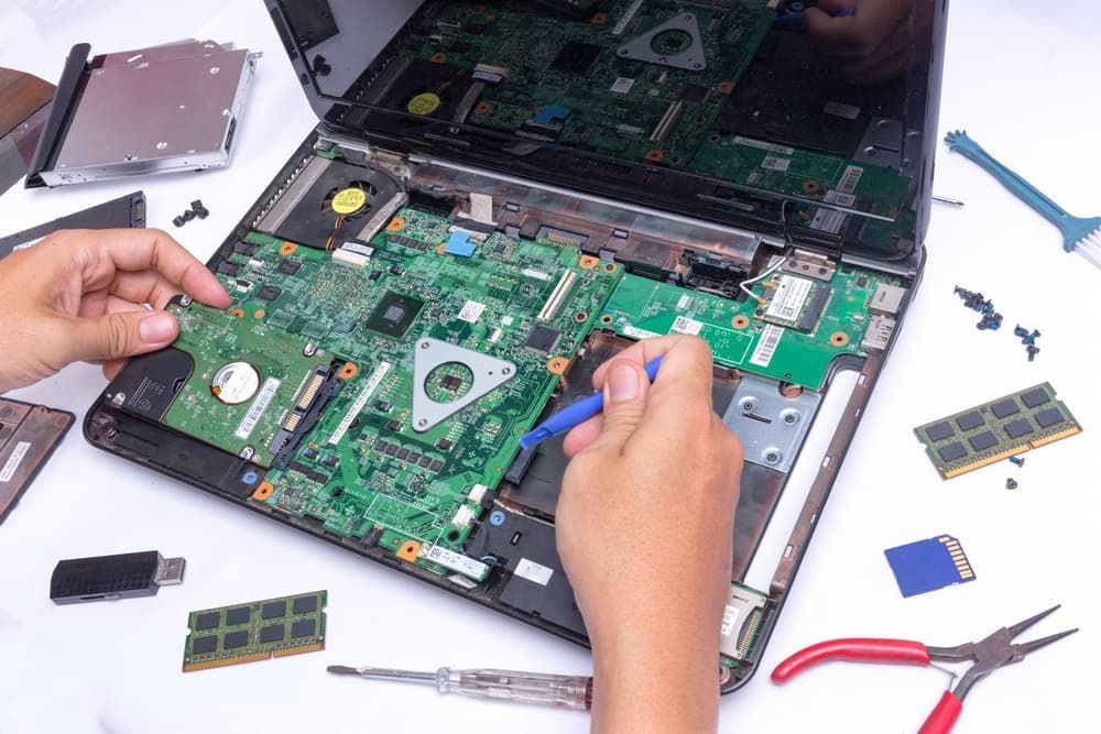 A Person is Repairing a Laptop Computer With a Screwdriver — Leading Edge Computers in Forster, NSW