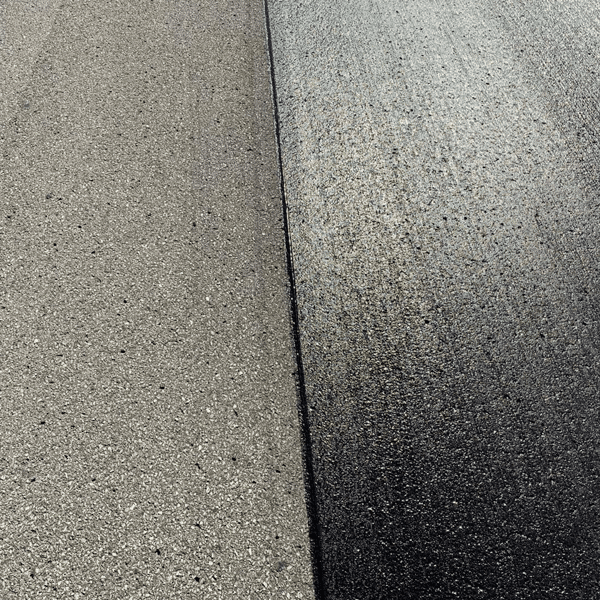 Close-up of two concrete pavement slabs separated by a dark expansion joint, with a shadowed edge on the right.