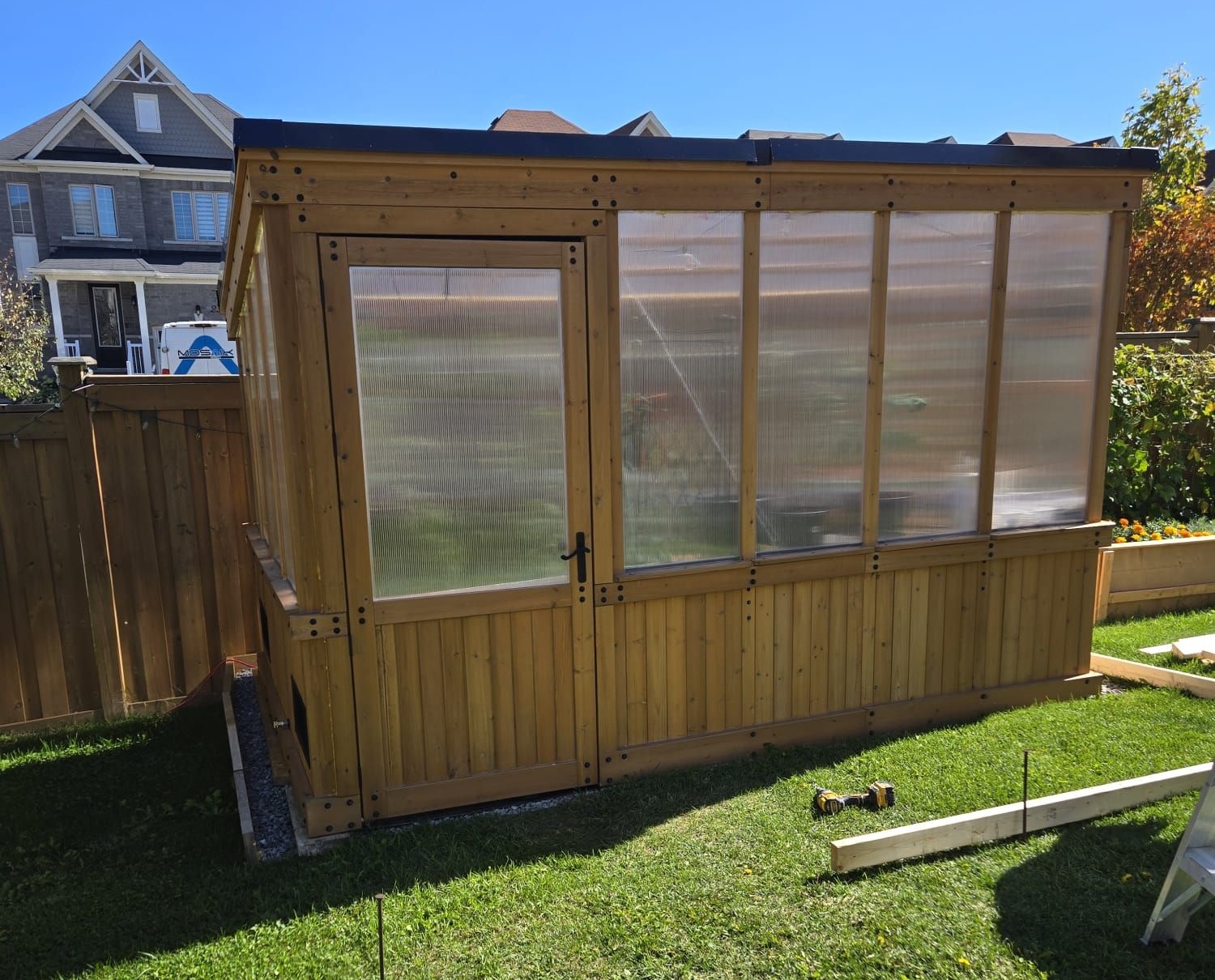 Backyard greenhouse in Canada during summer growing season