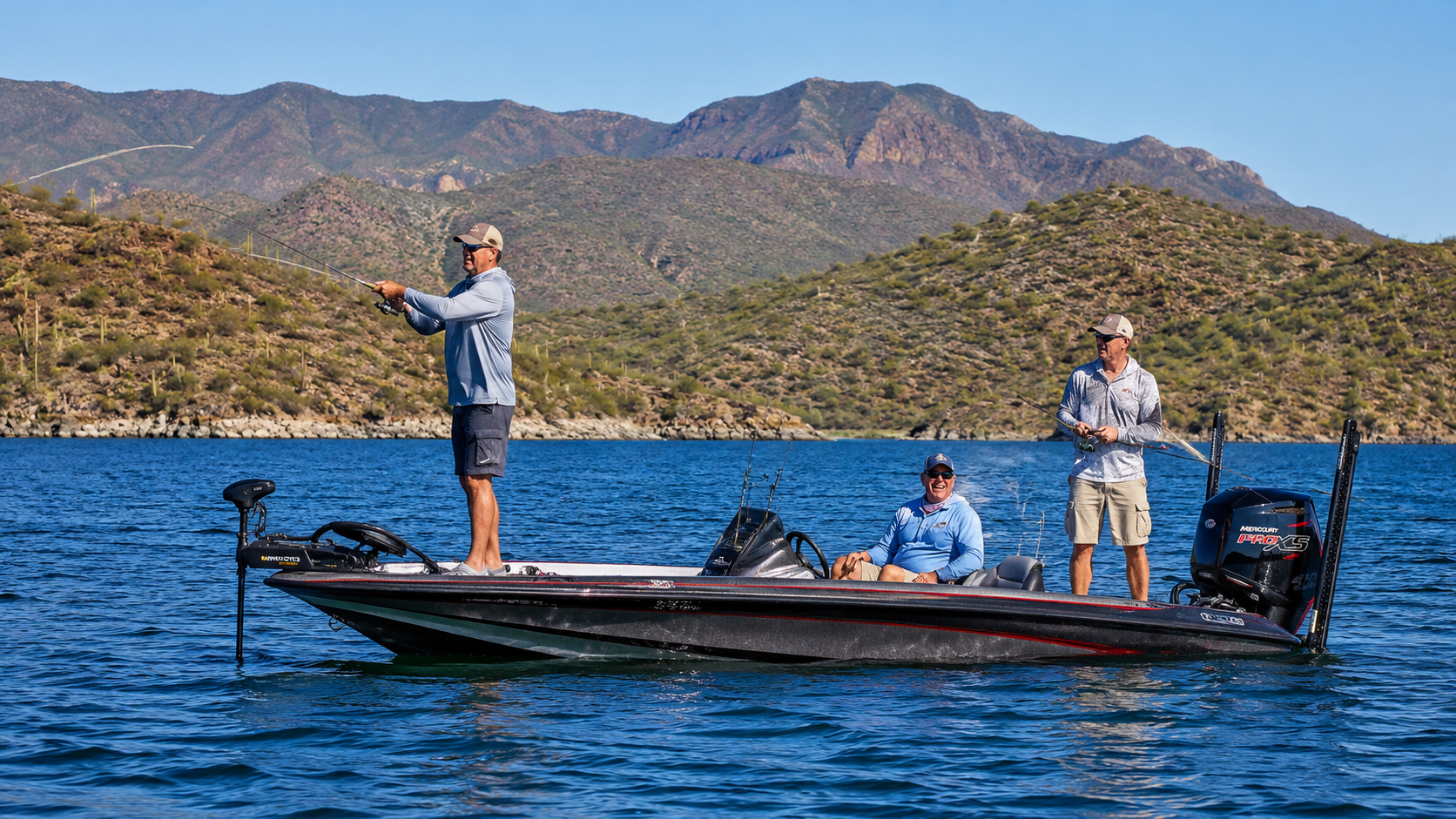 Two anglers on a bass boat fishing on a blue lake with mountains in the background