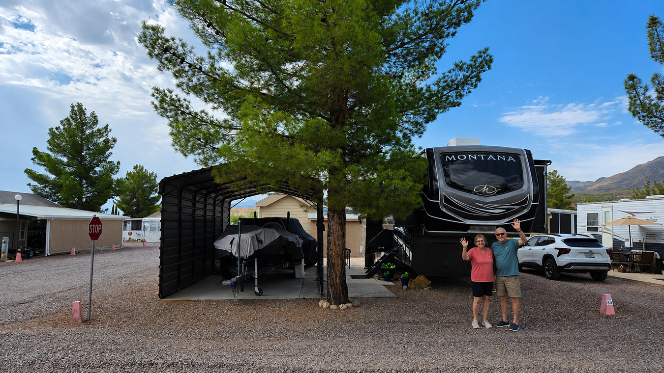 RVs parked on a gravel lot under a tree, with two people standing near the front rig.