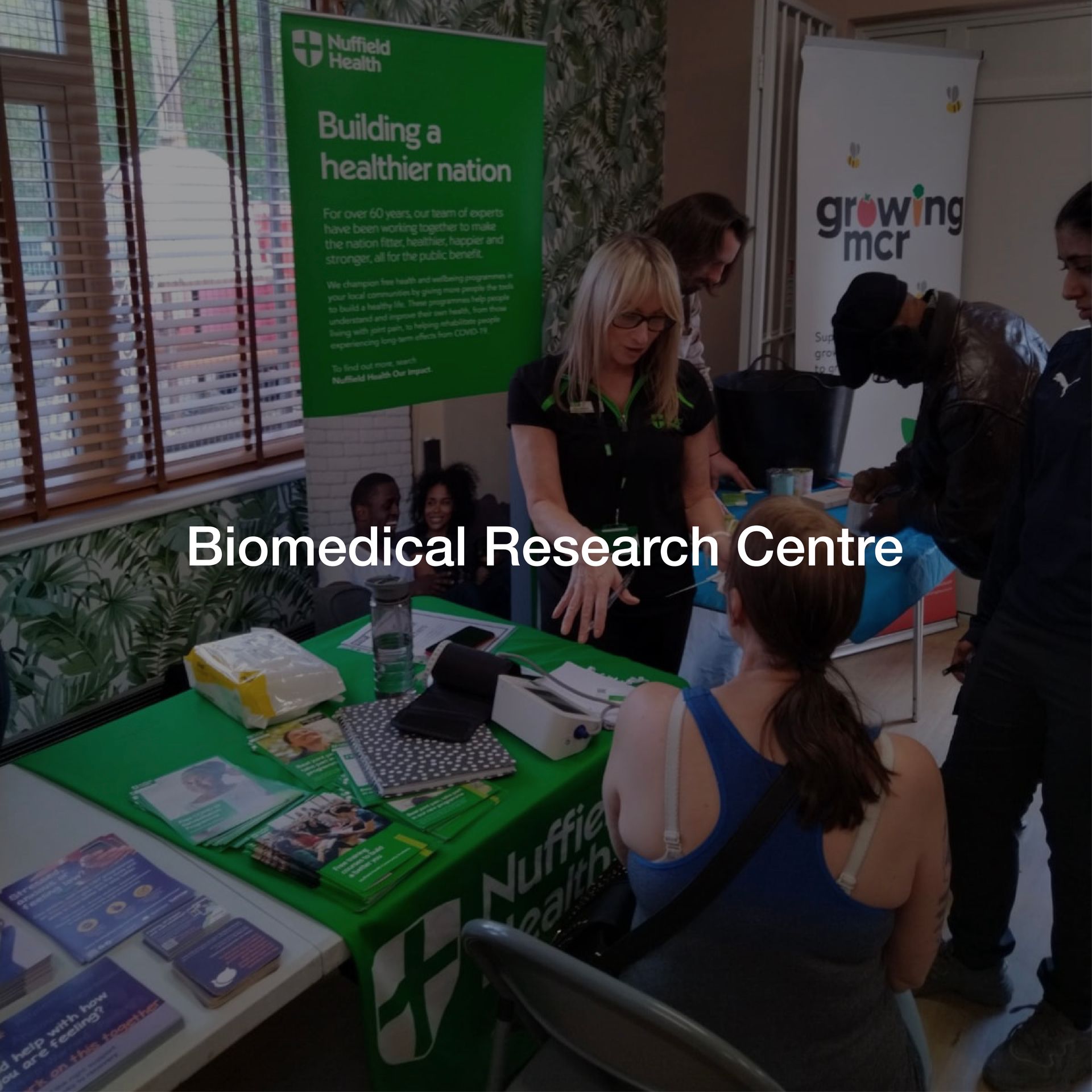 A group of people gathered around a table that says biomedical research centre