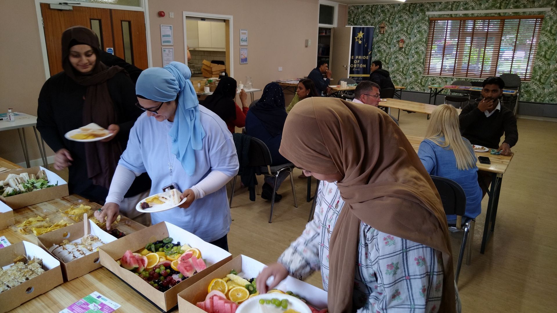 A group of women are standing around a table serving food.