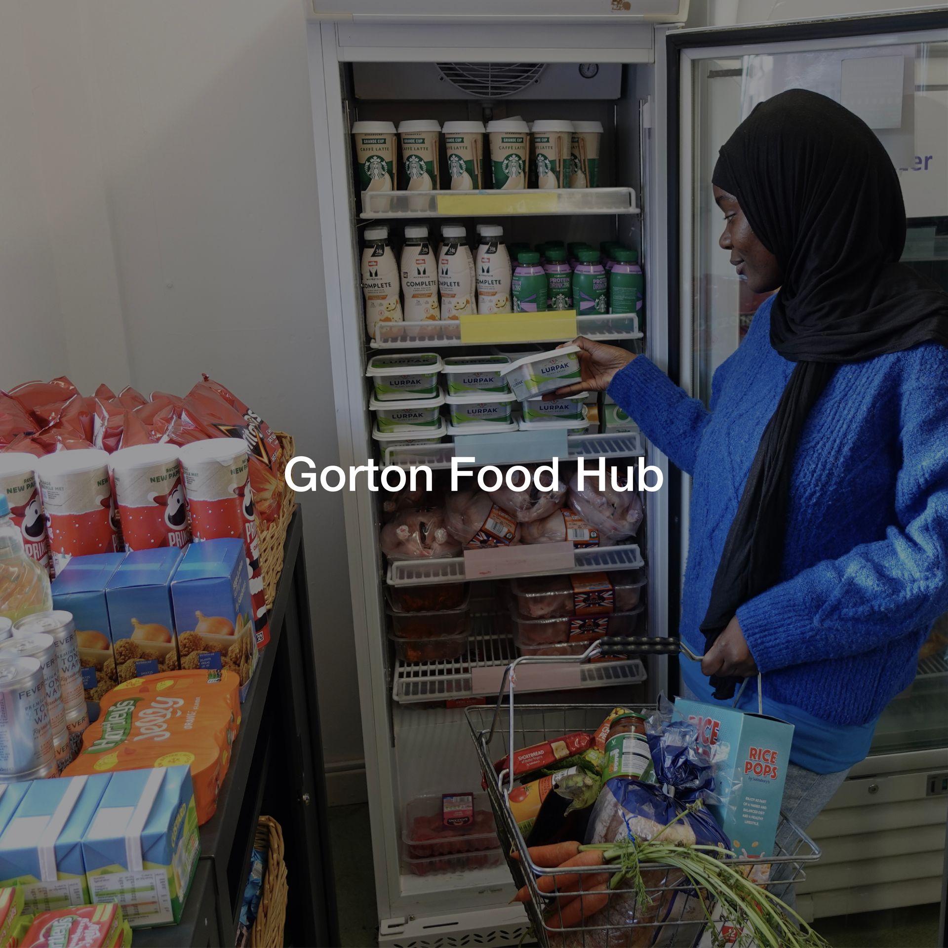 A woman standing in front of a refrigerator that says gorton food hub
