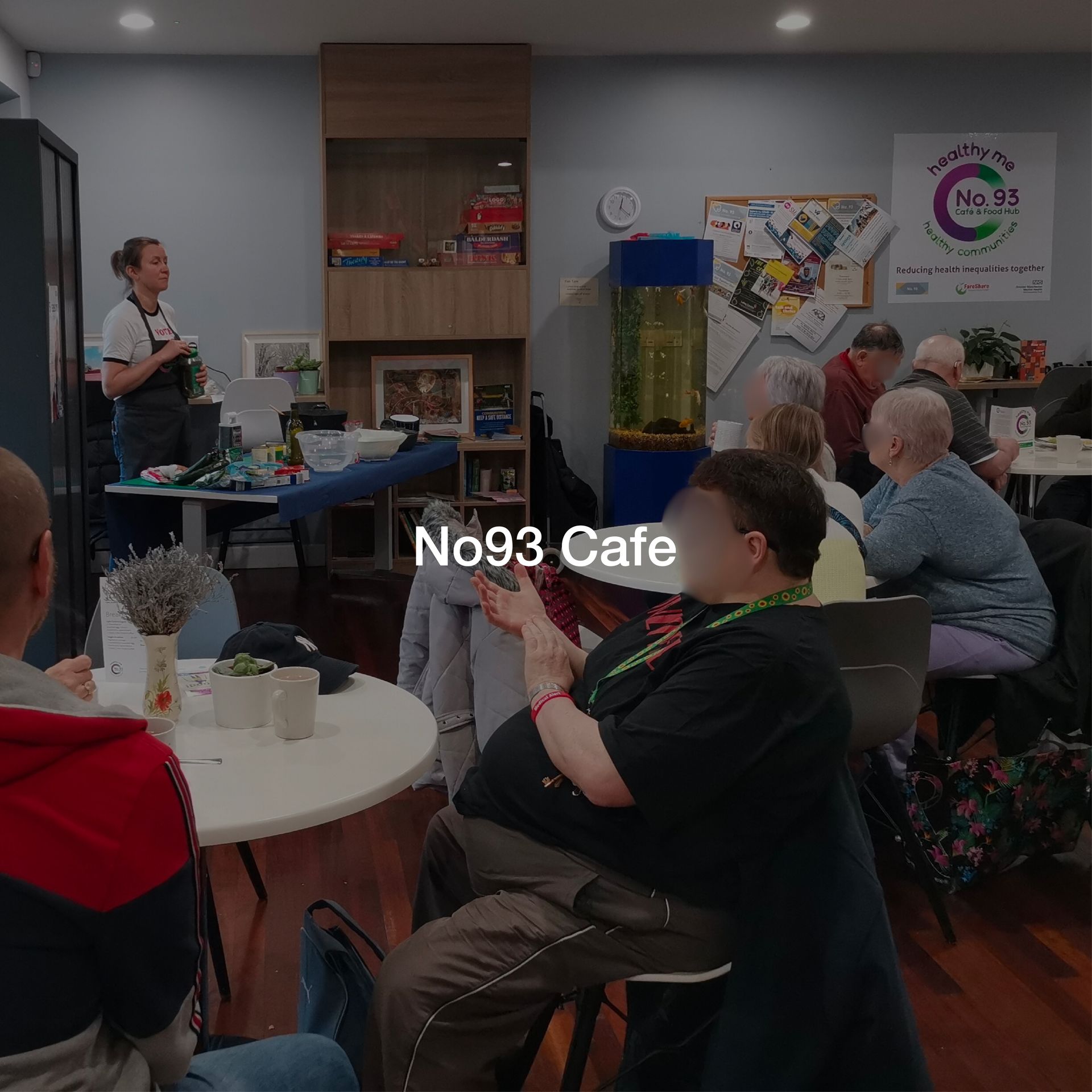A group of people are sitting at tables in a cafe.