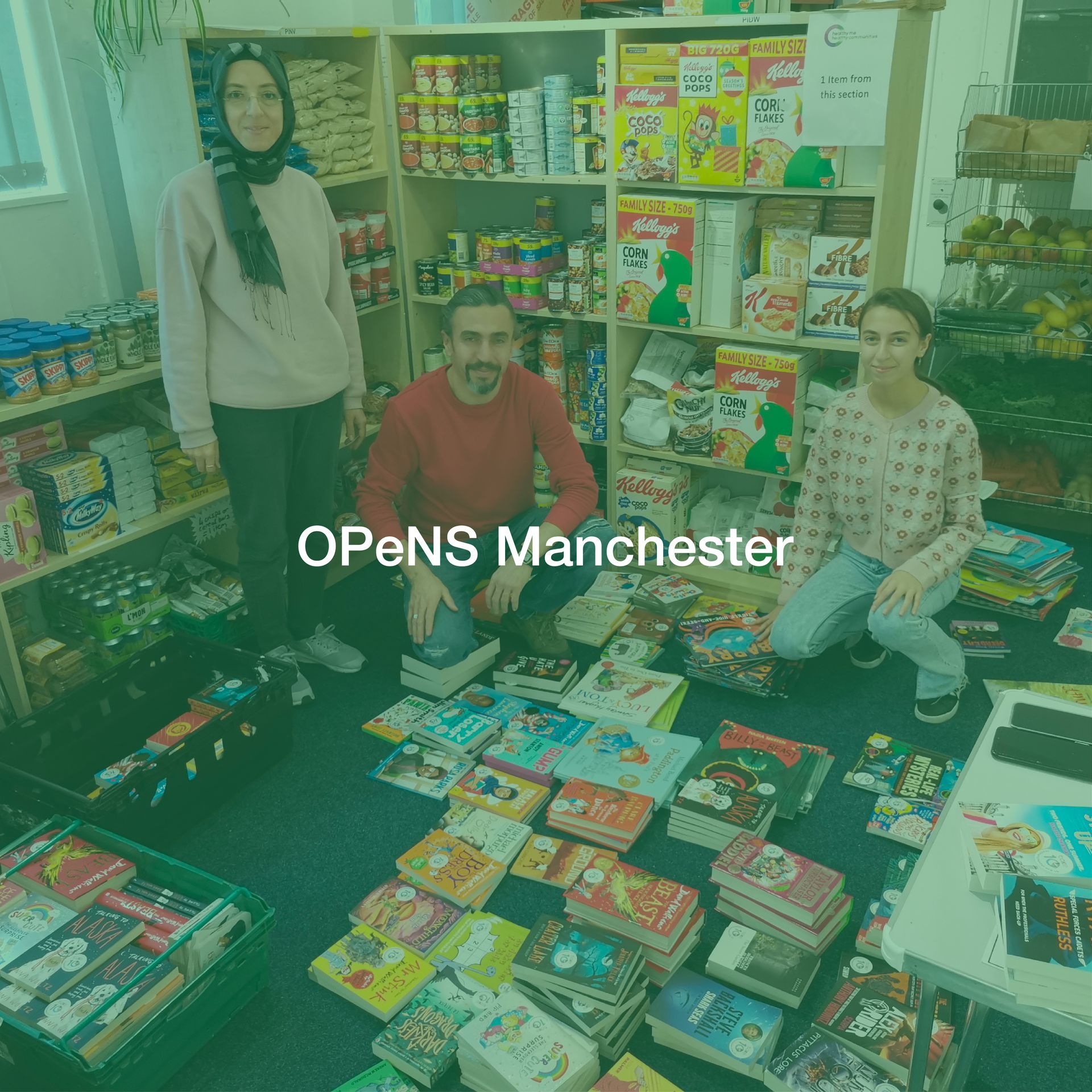 A group of people are sitting on the floor in a store surrounded by books.
