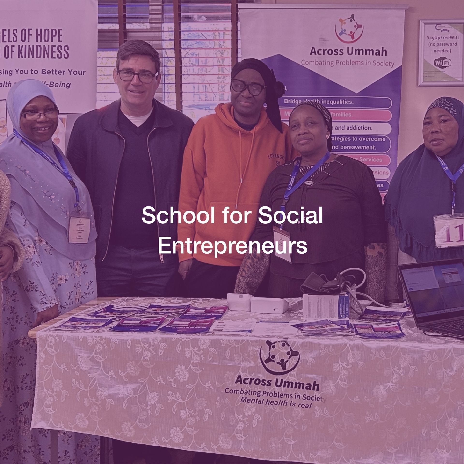 A group of people standing around a table that says school for social entrepreneurs