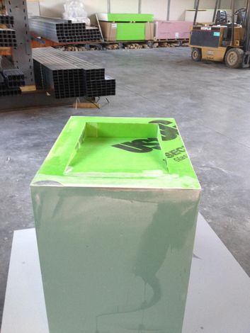 Una stanza interna non rifinita con pareti in cartongesso, soffitto a cassettoni, camino e porte a vetri che conducono all'esterno.