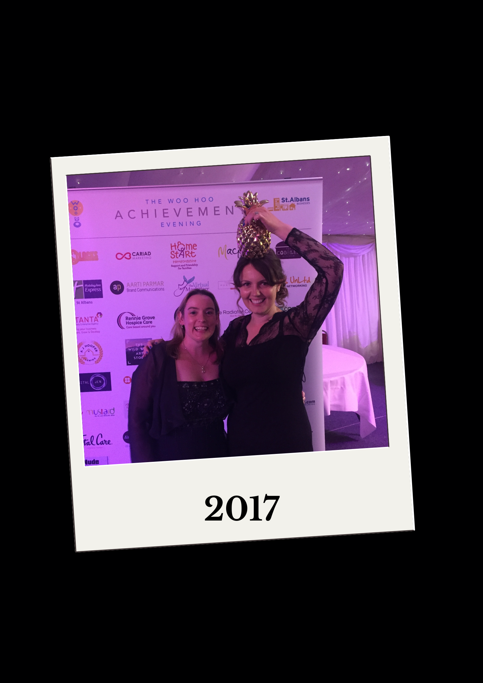 Lisa smiling with Lou holding her pineapple trophy on her head
