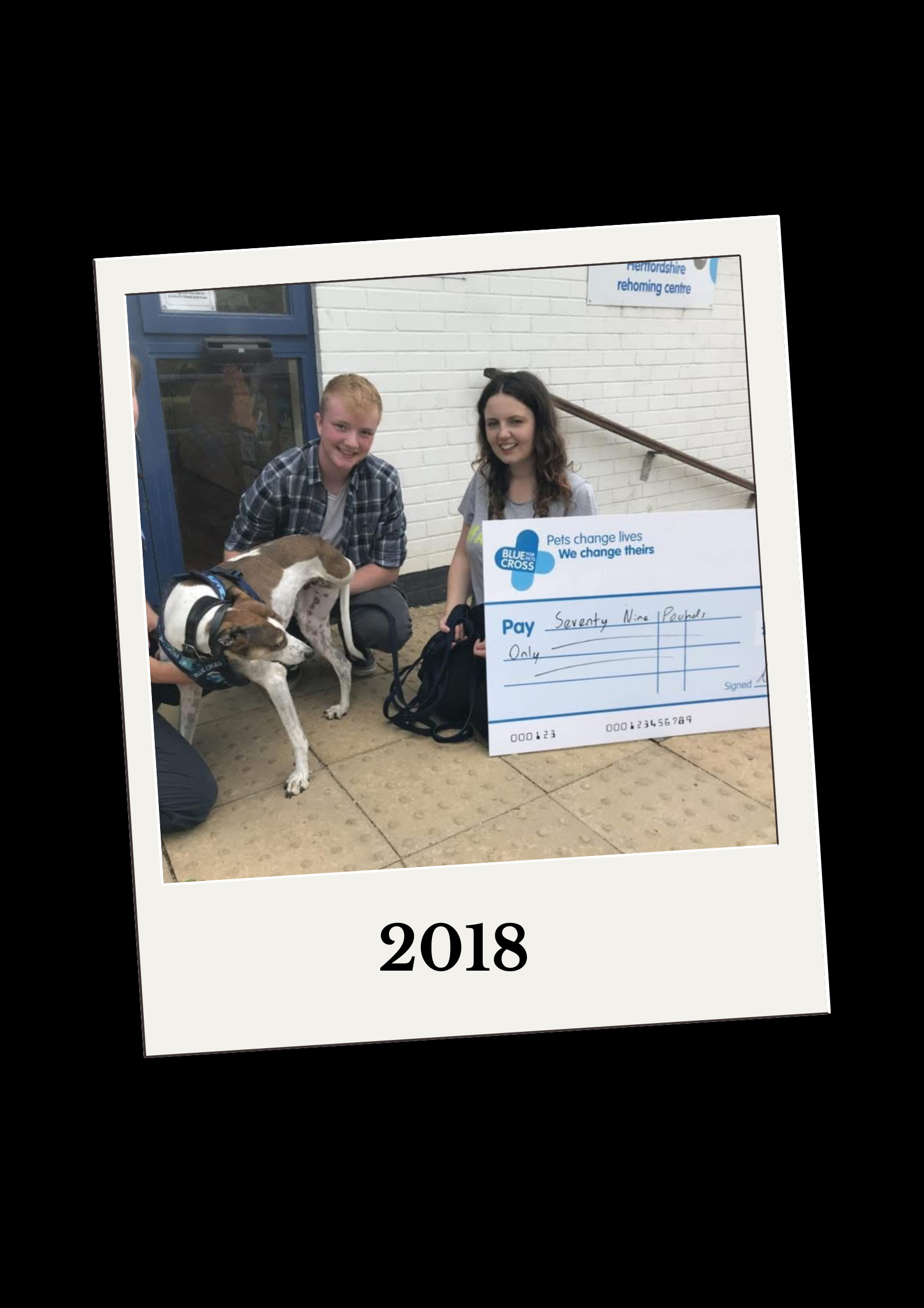 Lisa sitting with Asher and Dolly a 3 legged dog next to a cheque.