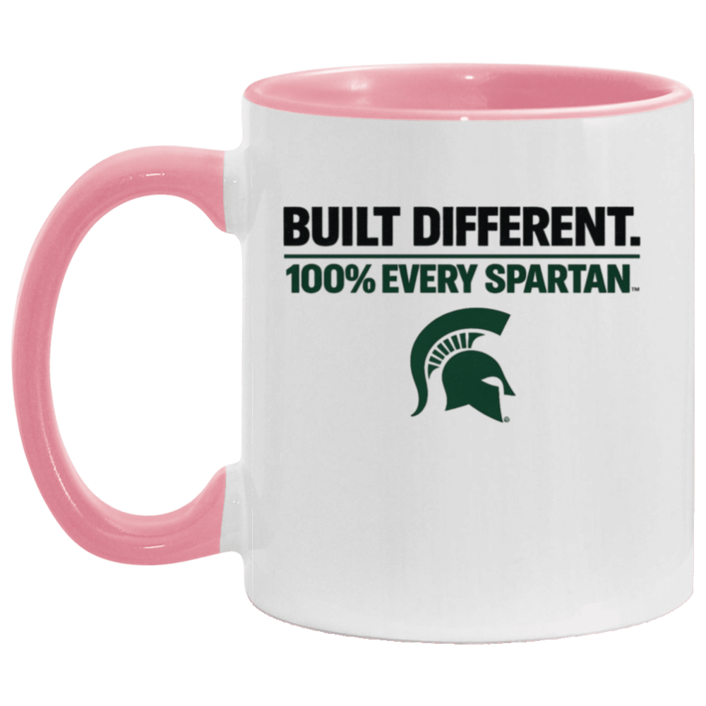 White mug with pink handle and rim, printed with “BUILT DIFFERENT. 100% EVERY SPARTAN.” and a green Spartan helmet logo