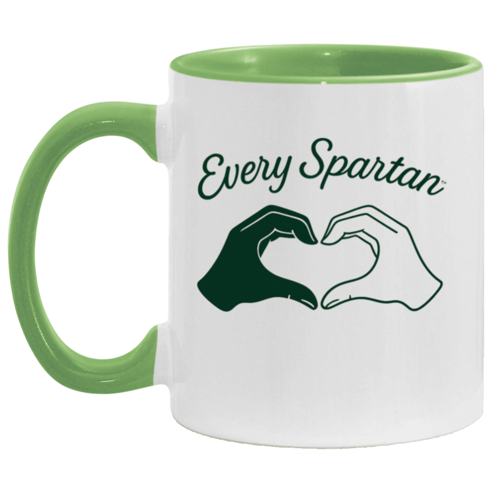 White mug with green rim and handle reading “Every Spartan” above two hands forming a heart.