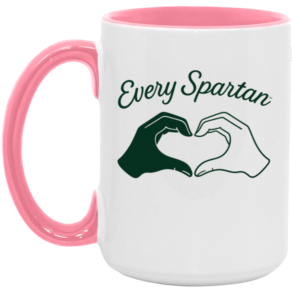 White mug with pink handle and rim reading “Every Spartan” with hands forming a heart
