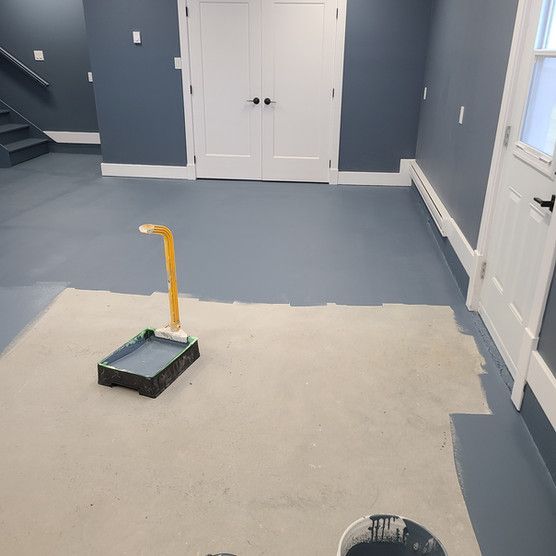A room with a bucket of paint on the floor