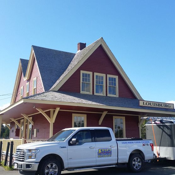 A white truck is parked in front of a building that says louisburg