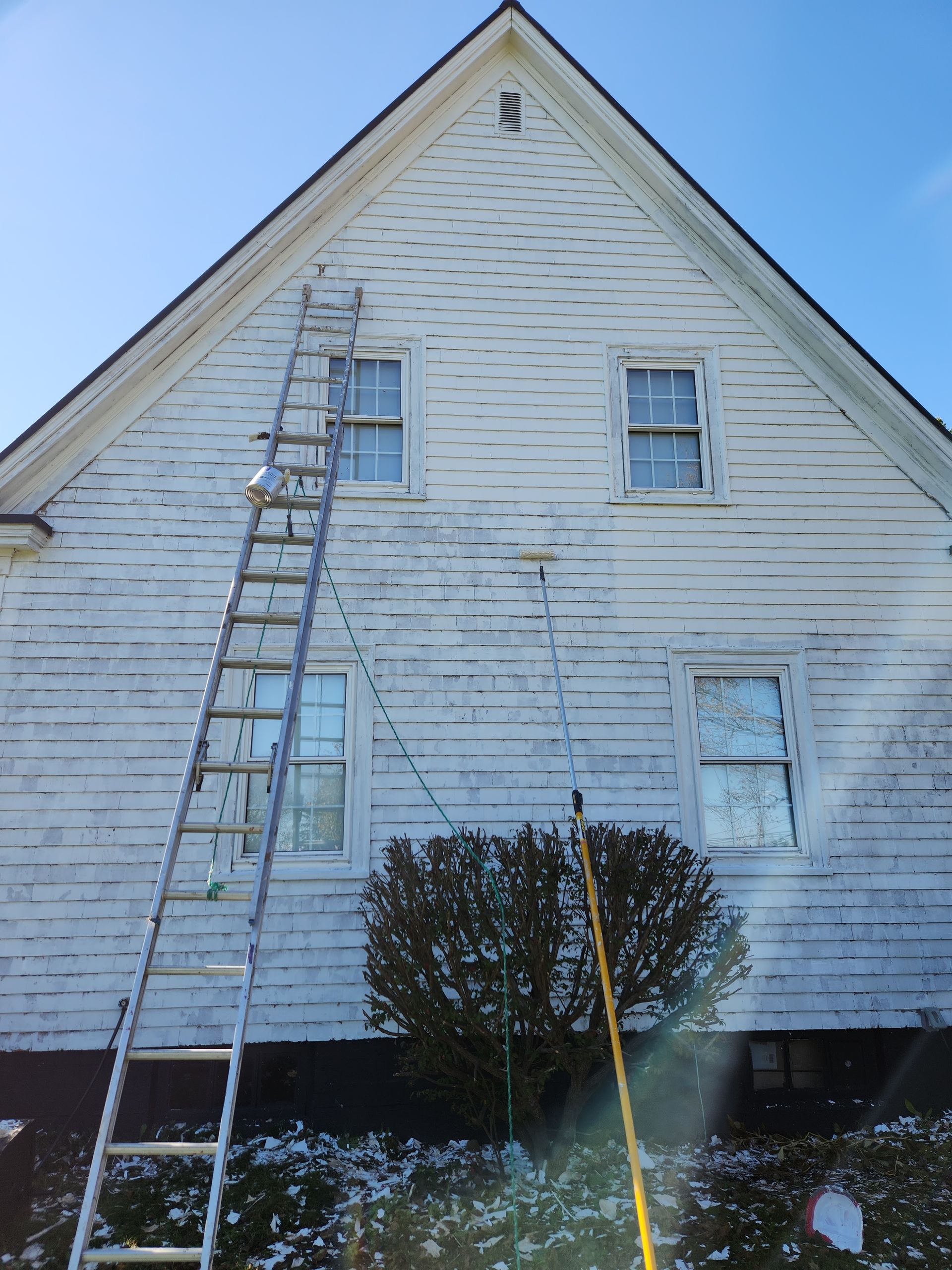 A white house with a ladder in front of it