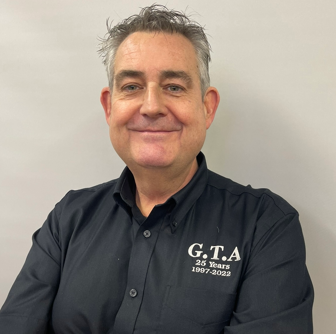 A man wearing a black shirt that says g.t.a on it