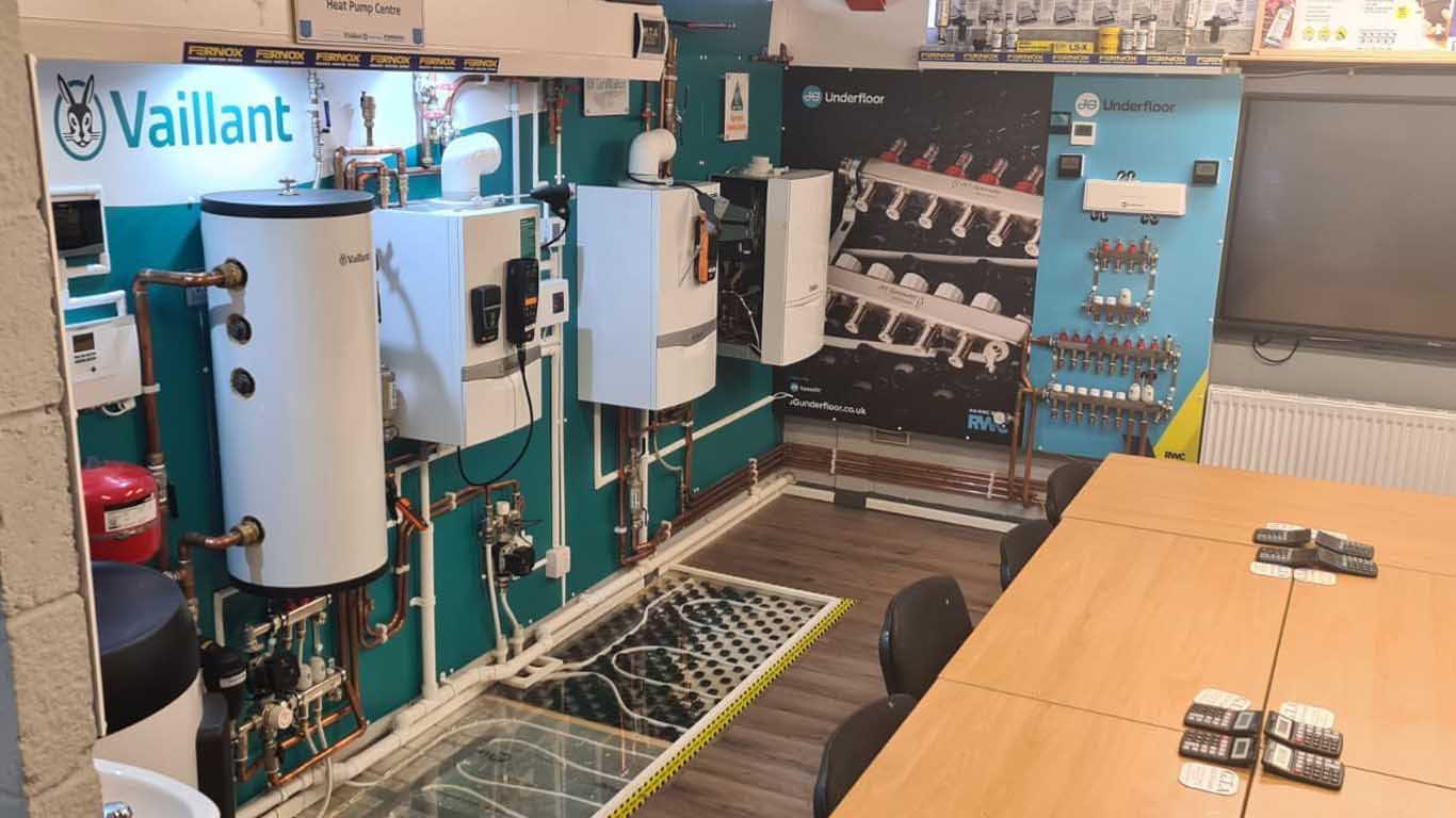 A room with a table and chairs and a display of boilers.