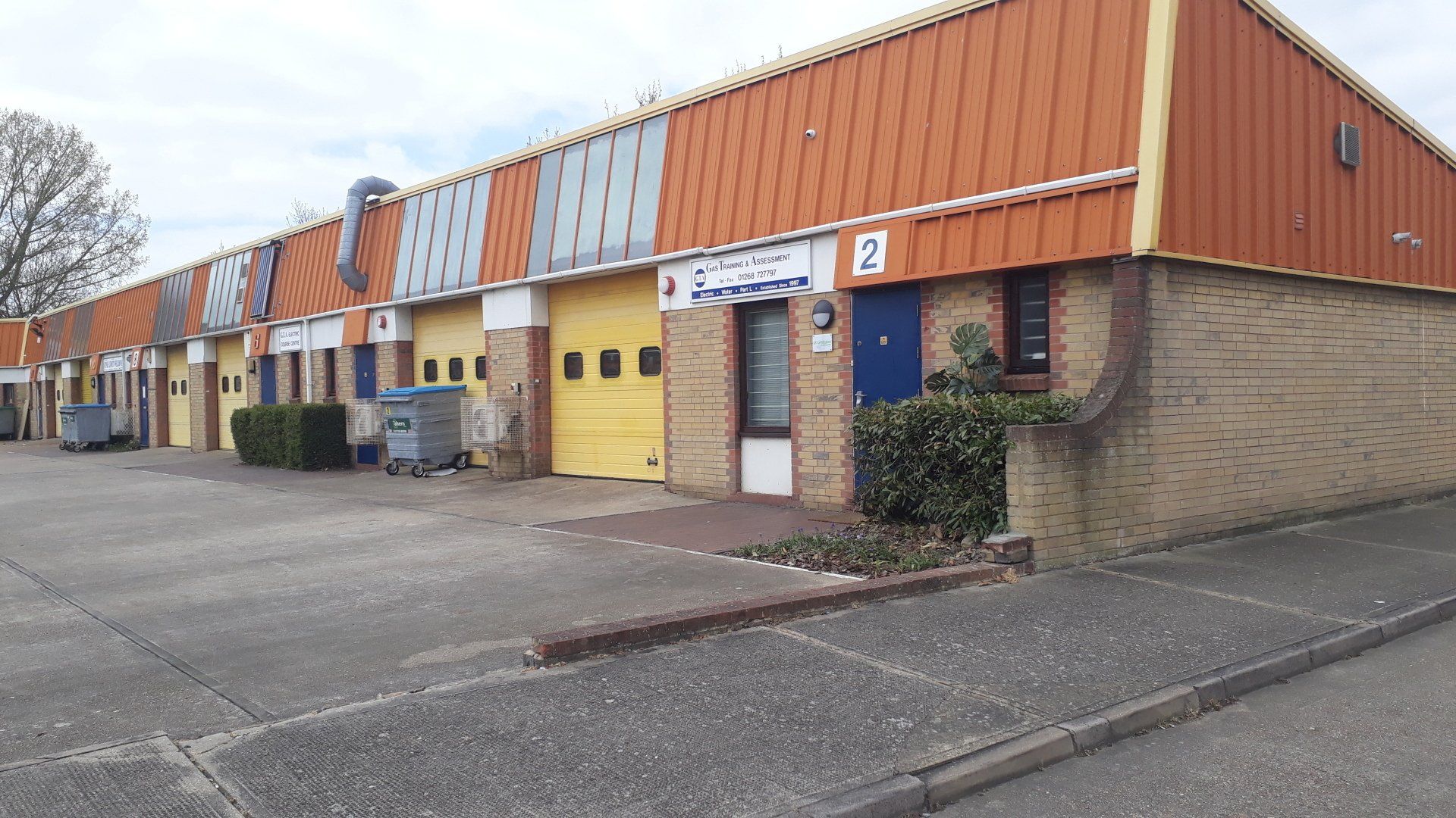 A row of buildings with orange roofs and yellow garage doors.