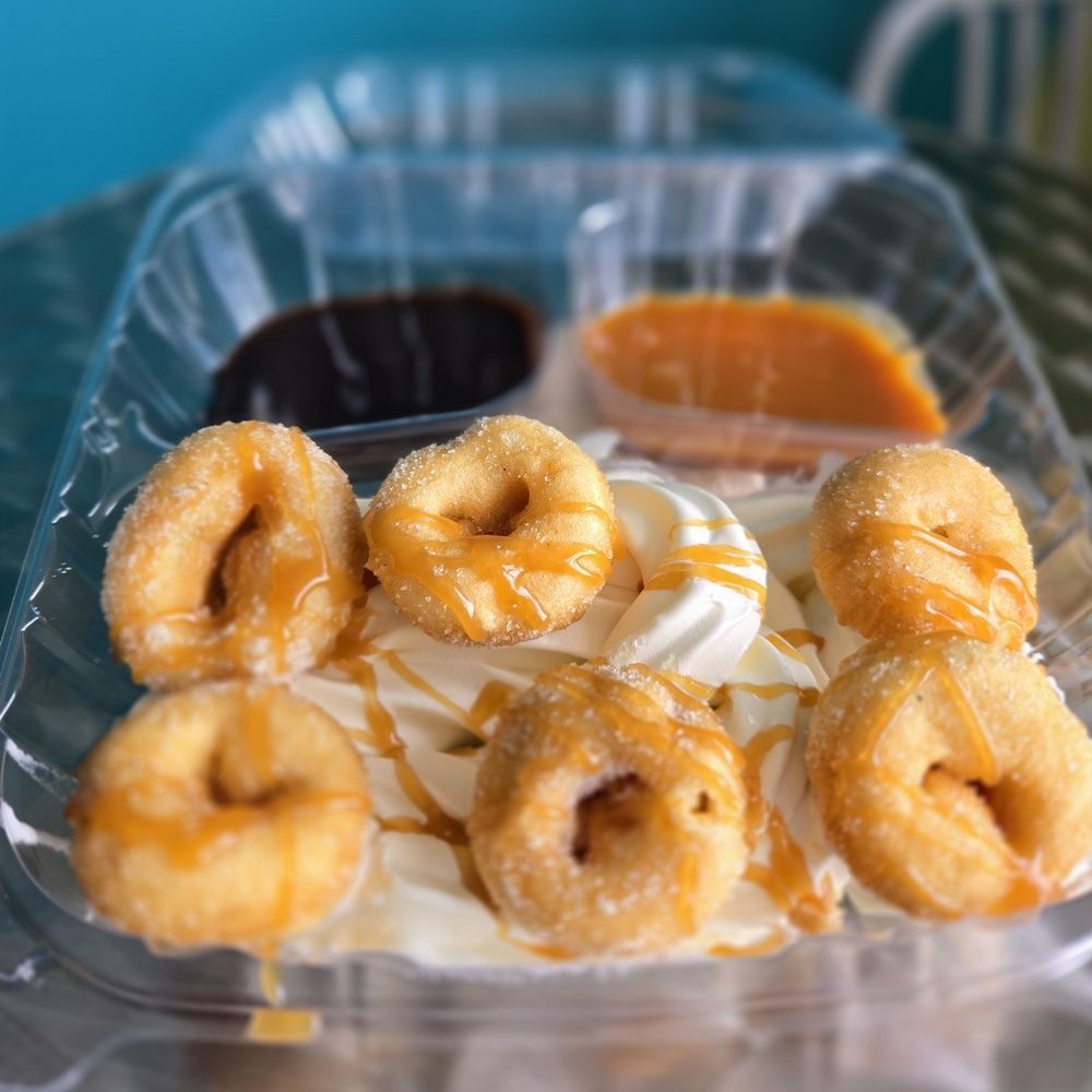 A plastic container filled with donuts and ice cream.