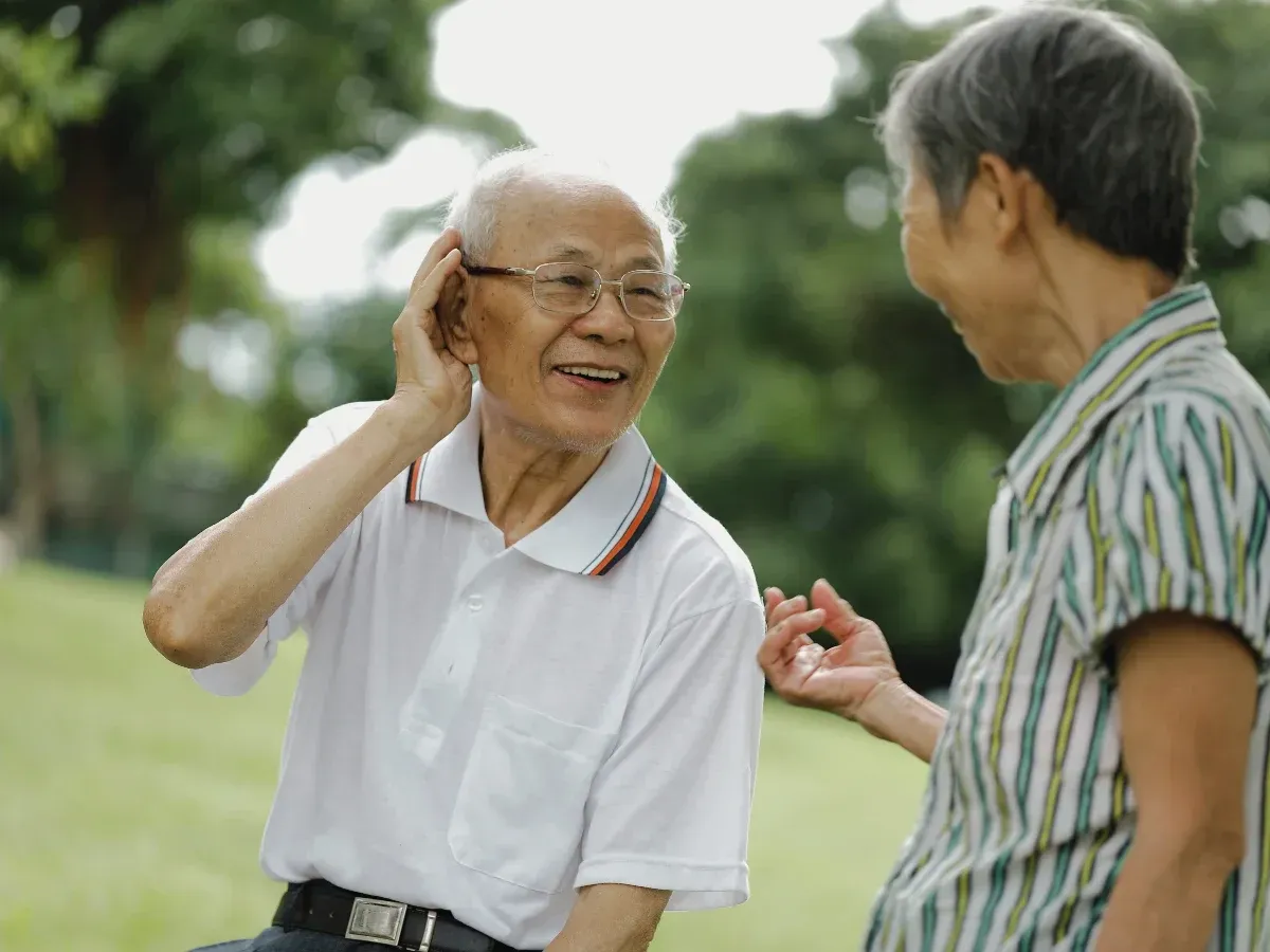 Elderly man and woman conversing outdoors
