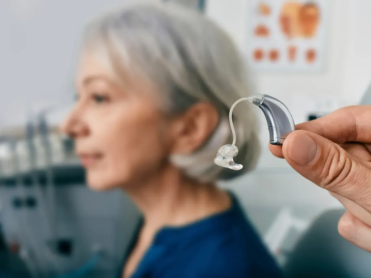 hearing aid held in front of an elderly woman