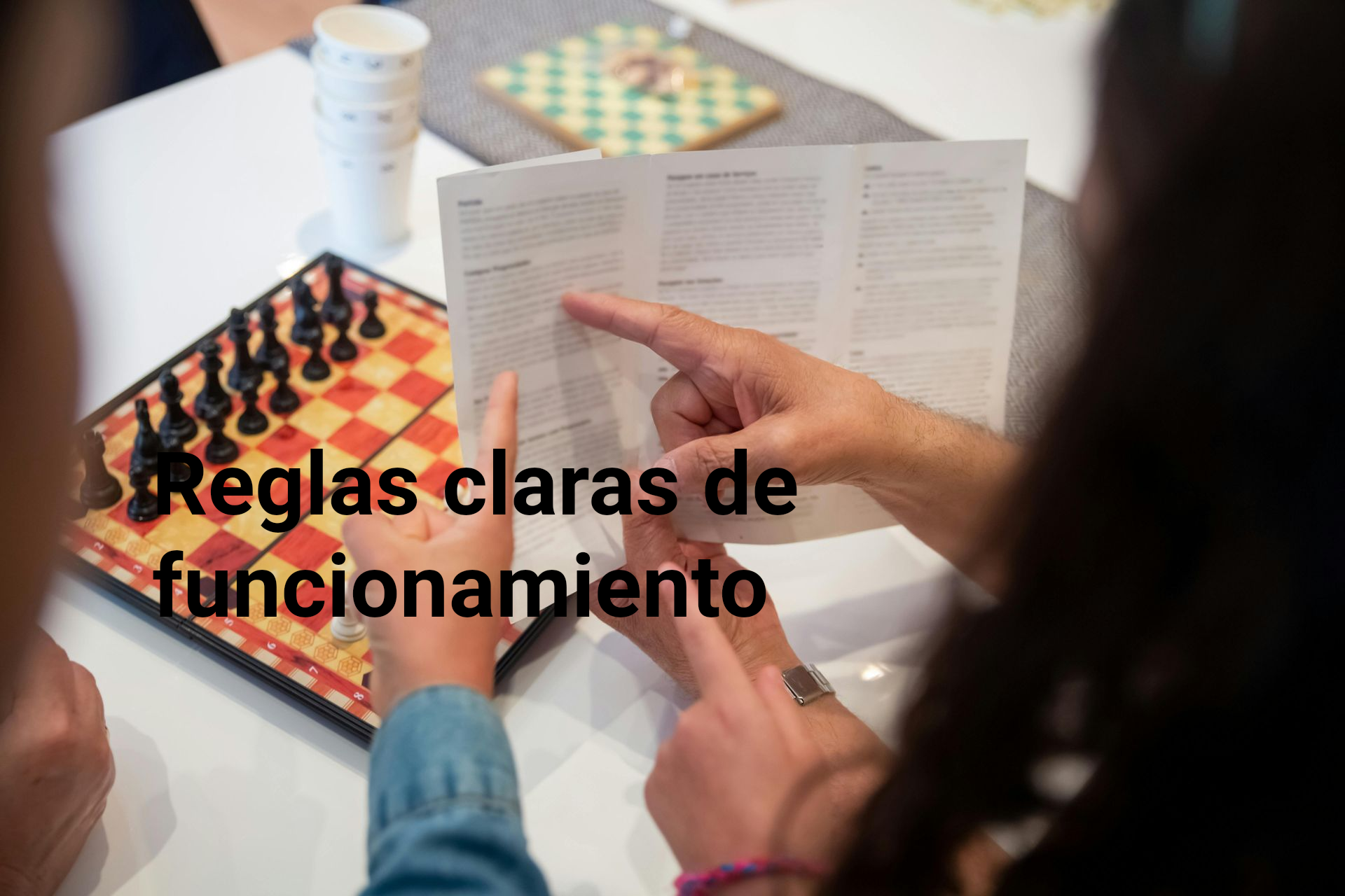 People pointing at rule book over chessboard; text: 