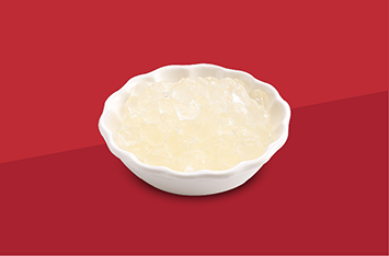 White bowl of mashed potatoes on a red background