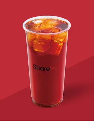 Tall cup of iced red beverage with ice on a red background