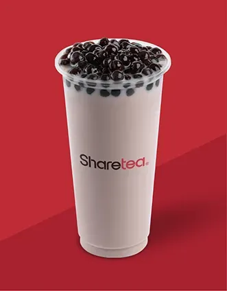 Tall white cup of bubble tea topped with black pearls on a red background