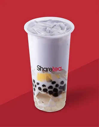 Clear plastic cup of milk tea with black tapioca pearls on a red background