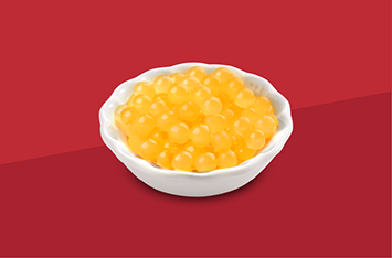 White bowl of yellow caviar on a red background