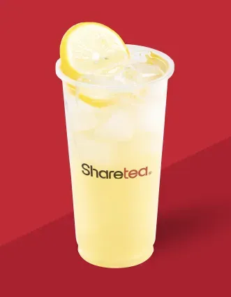 Clear beverage cup with lemon slices and the word “Sharetea” on a red background