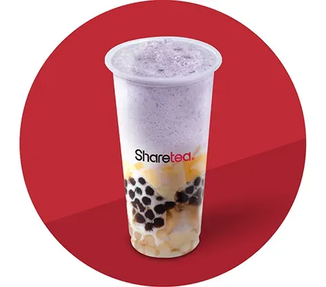 Clear plastic cup of milk tea with tapioca pearls on a red background
