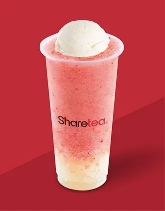 Pink strawberry drink with a scoop of vanilla ice cream on top, in a clear cup against a red background