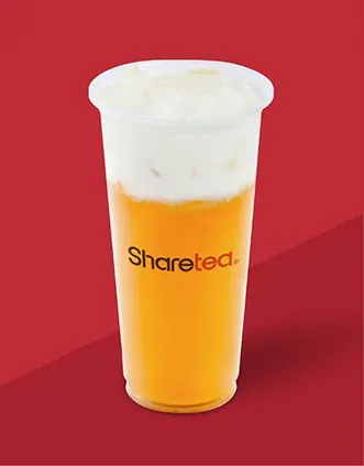 Tall clear cup of orange iced drink with white foam, branded “Sharetea,” on a red background