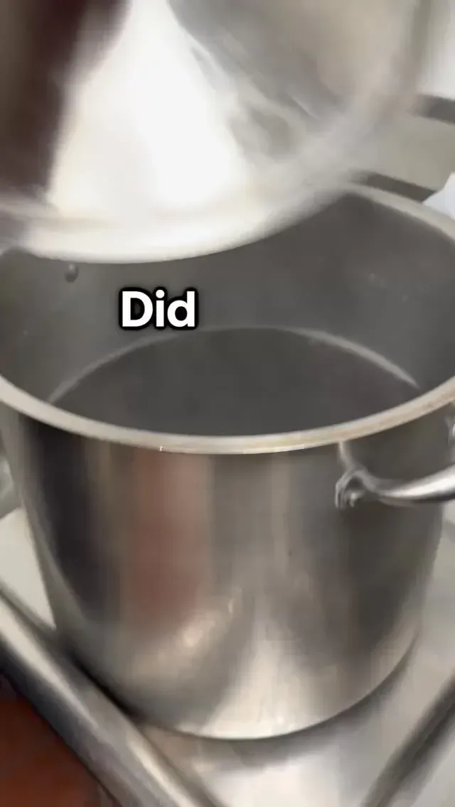 Metal pot on a stovetop as liquid is being poured in; text reads “Did”