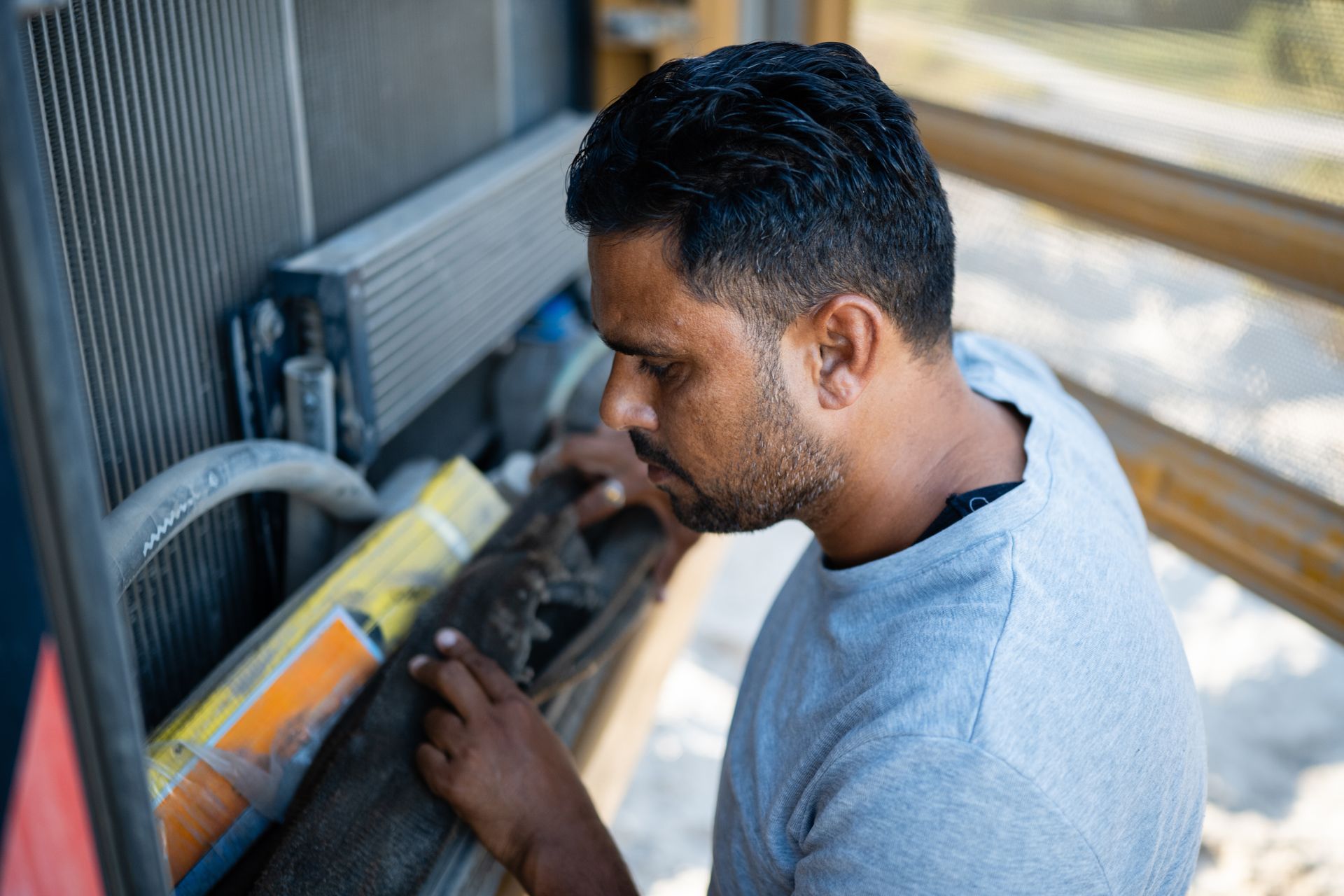 A manufacturer is inspecting the radiator of a heavy-duty vehicle during a maintenance check.