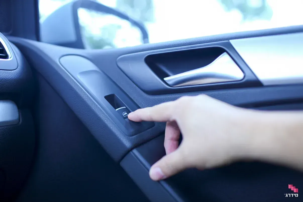 A person is pressing a button on the door of a car.