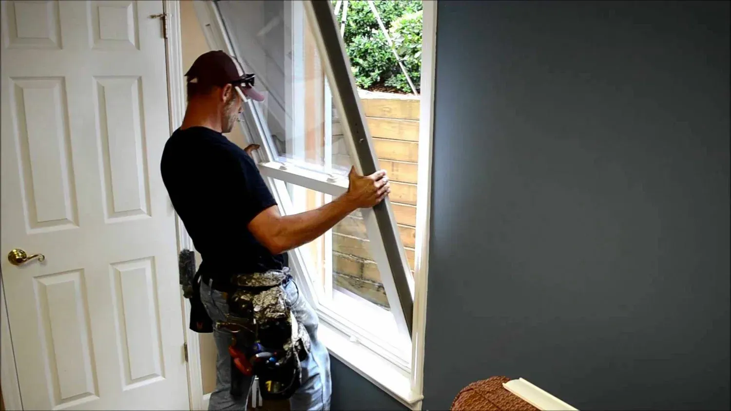 A man is installing a window in a room.