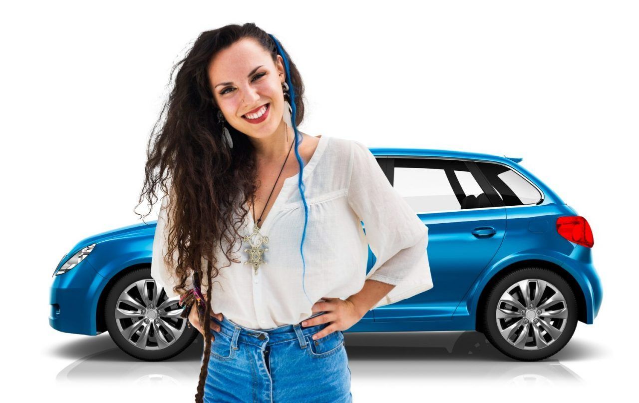 A woman is standing in front of a blue car.
