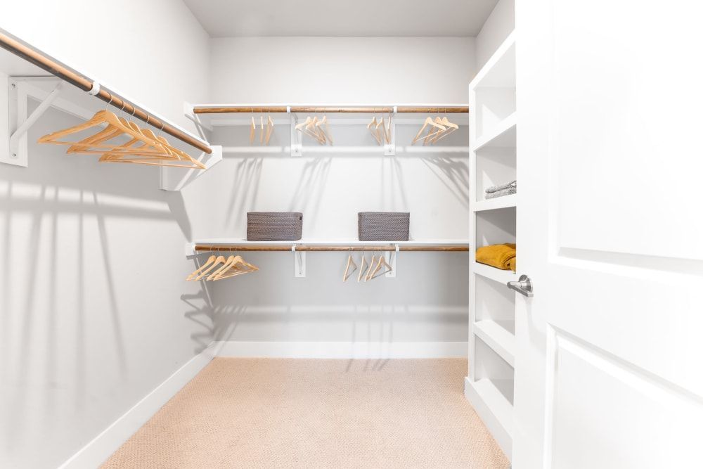 A walk in closet with a lot of shelves and clothes hanging on the racks at The Bennett, which offers apartments for rent near downtown Austin, TX.