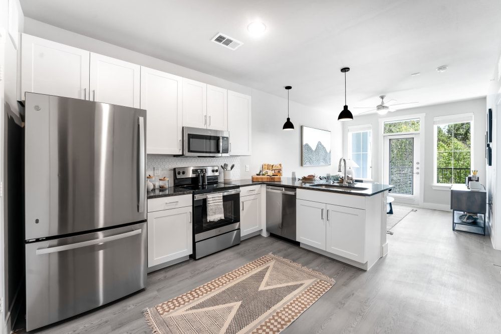 A kitchen with stainless steel appliances and white cabinets at The Bennett, which offers apartments for rent in South Austin, TX.