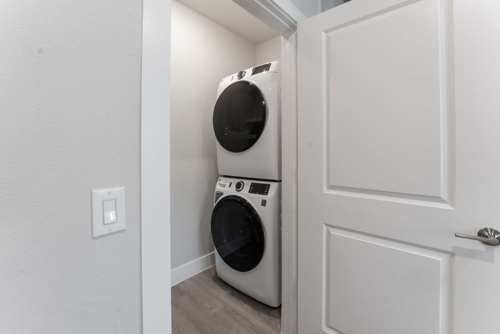 A washer and dryer are stacked on top of each other in a laundry room at The Bennett, which offers apartments for rent close to downtown Austin, TX.