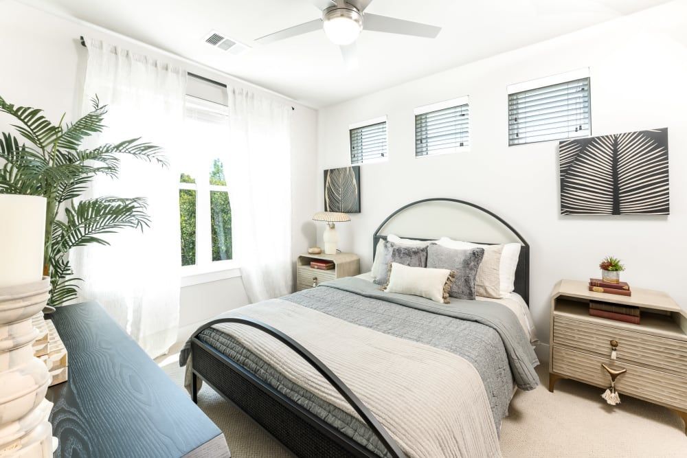 A bedroom with a bed, nightstands, and a ceiling fan at The Bennett, which offers apartments in South Austin, TX.