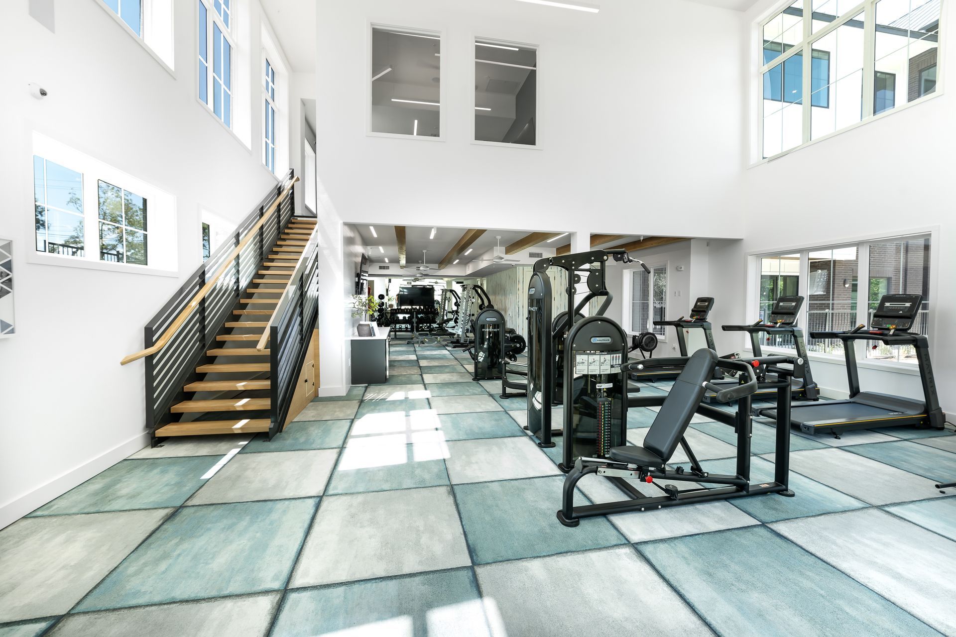 A large gym with a lot of equipment and stairs at The Bennett, which offers apartments for rent in South Austin, TX.