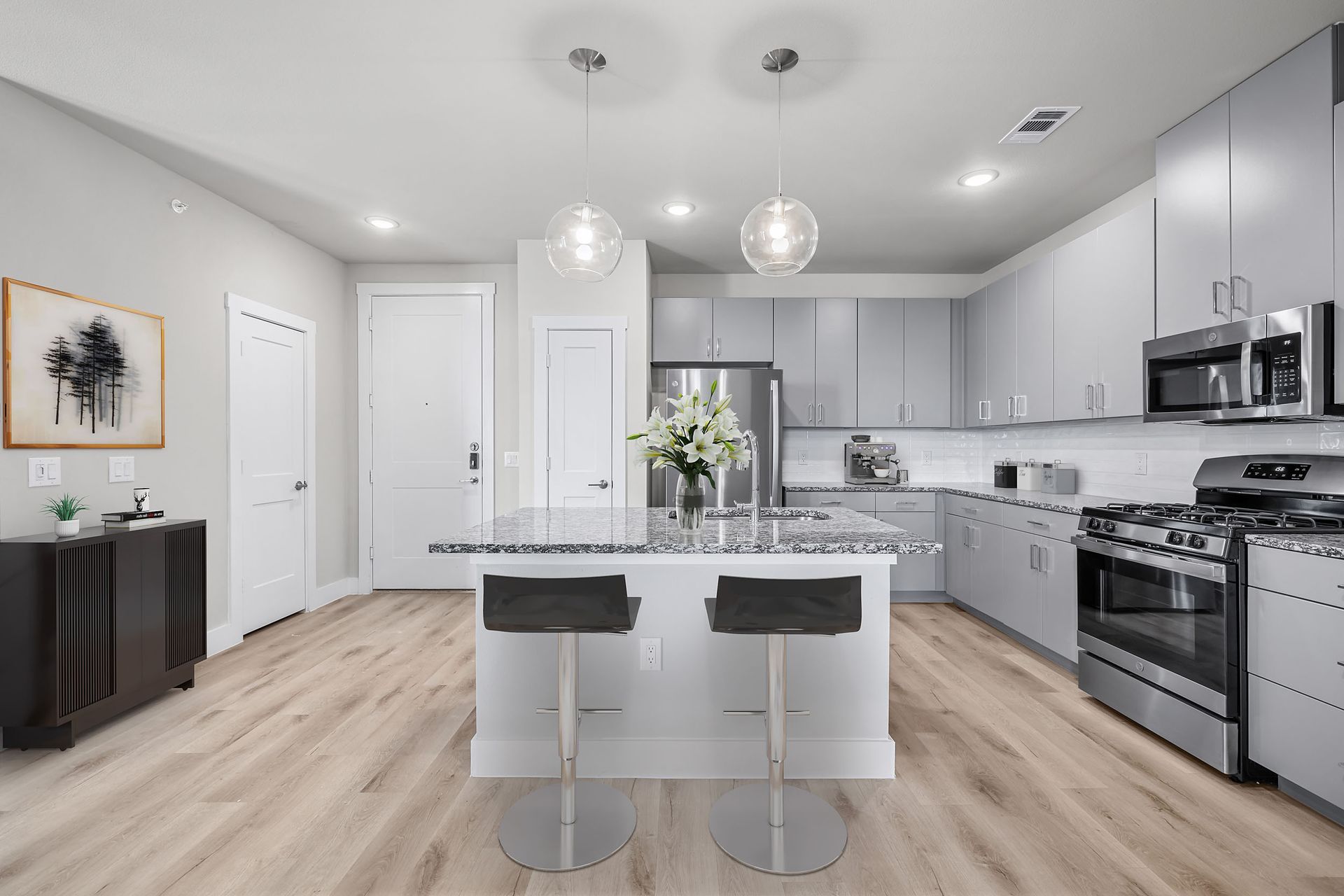 A kitchen with stainless steel appliances and a large island in the middle at The Bennett offers apartments for rent in South Austin, TX.