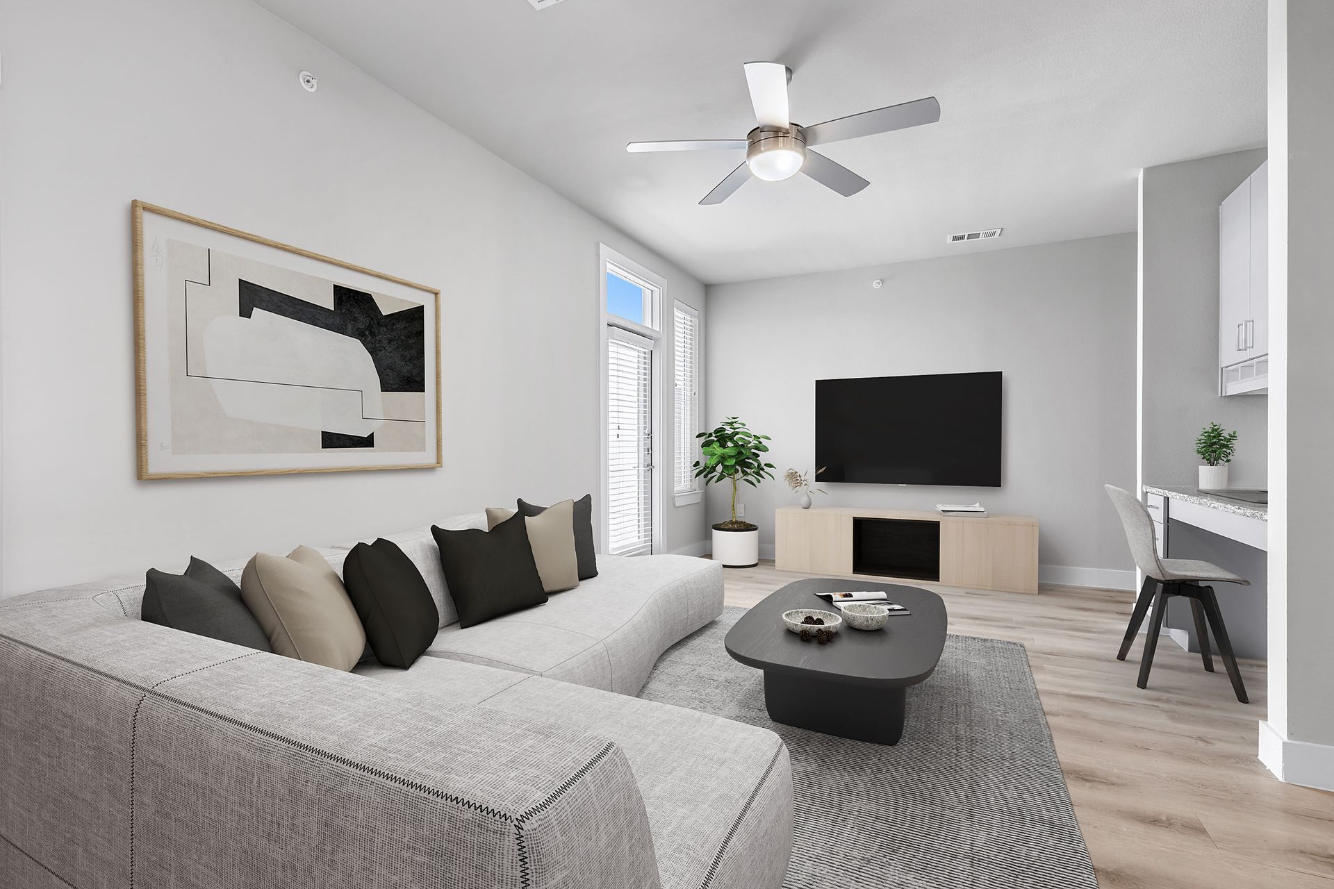 A living room with a couch, coffee table, television, and ceiling fan at The Bennett, which offers apartments for rent in South Austin, TX.