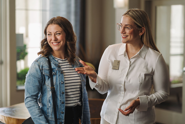 Two coworkers smiling in an officeSequoia West Coast Multifamily Property Management.