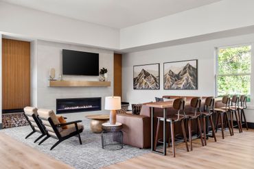 Modern living room, dining table, and mountain wall art Sequoia West Coast Multifamily Property Management.